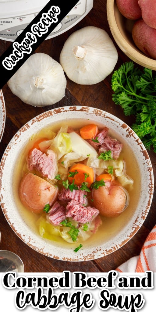 corned beef and cabbage soup in a bowl next to soup spoons, garlic, parsley on a wooden countertop