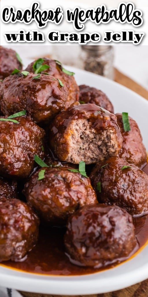 zoomed view of platter of crockpot meatballs with grape jelly and chilli sauce with a bite missing from one of the meatballs