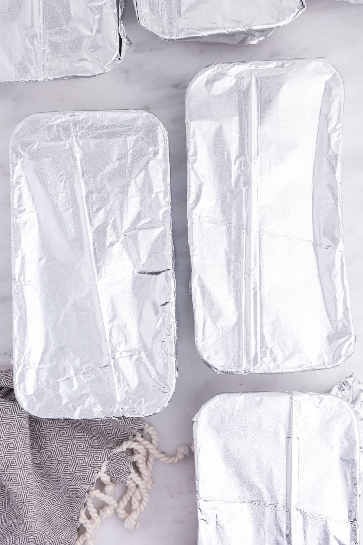 Prepared freezer chicken pot pies wrapped in aluminum foil.