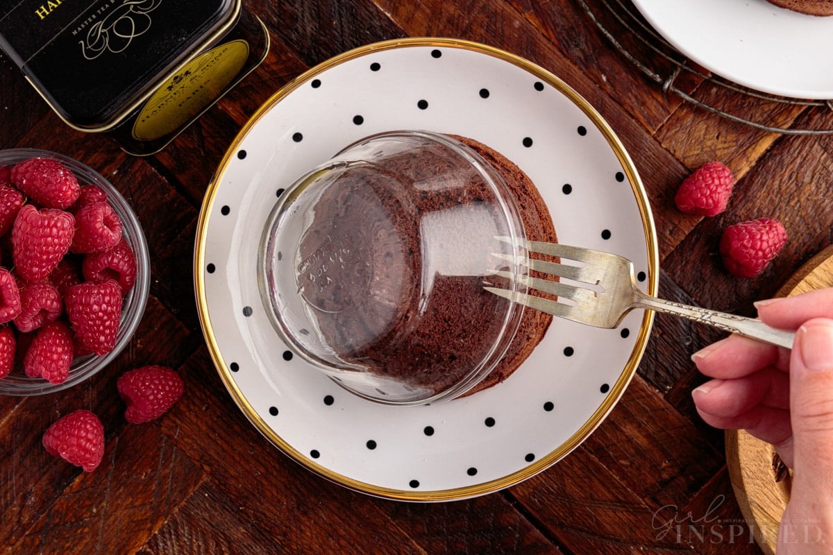 A Molten Lava Cake being taken from the ramekin and placed on a decorative plate.