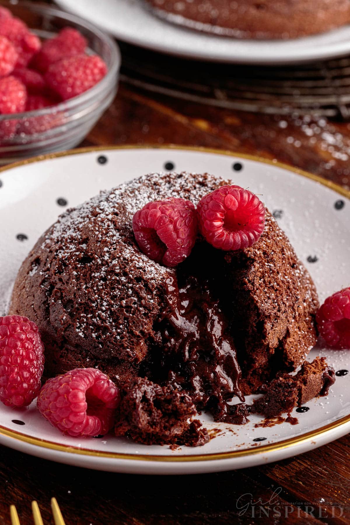 Close up of a plate of Molten Lava Cake with raspberries.