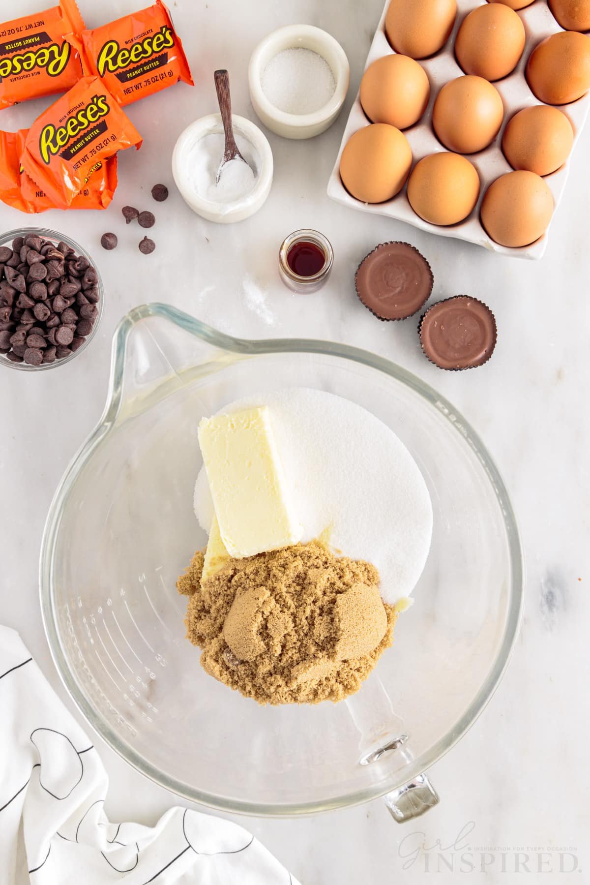Sugar, butter, and brown sugar in a mixing bowl next to additional ingredients.