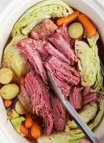 Top view of Crock-pot of slow cooker corned beef and cabbage with shredded corned beef.