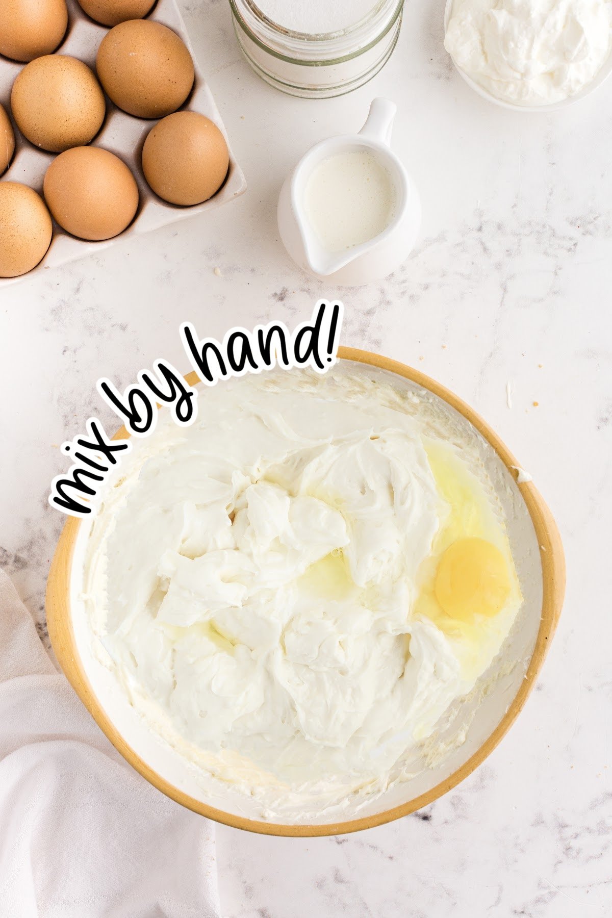 Eggs being added into the cream cheese mixture one at a time, with text overlay.