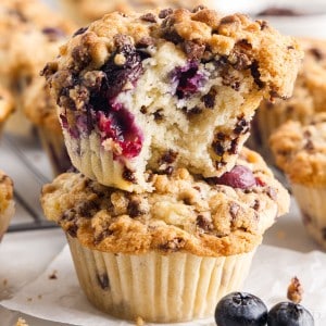 Stacked blueberry chocolate chip muffins with bite removed.