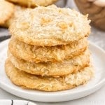 Four Chewy Coconut Cookies stacked on each other on a small plate.