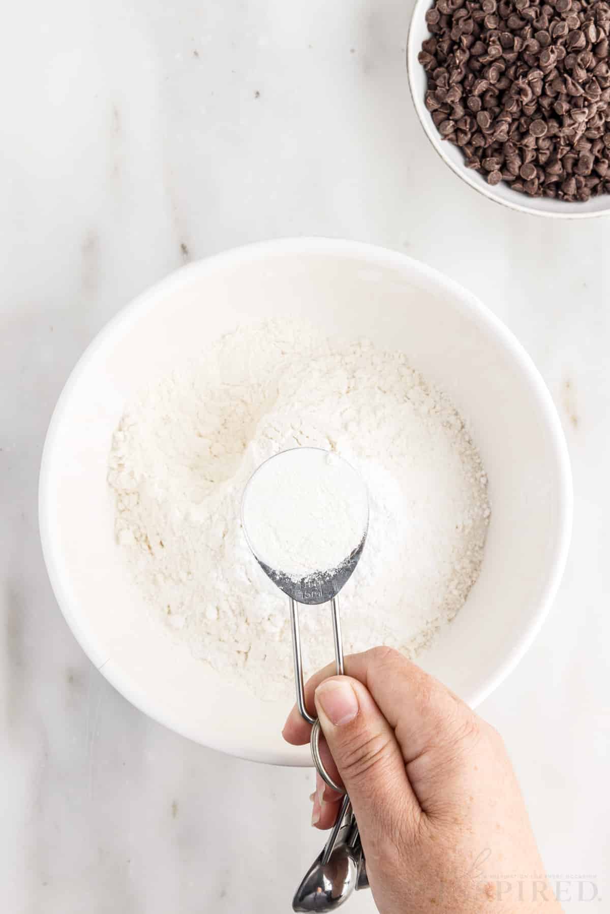 A tablespoon of flour of a bowl of flour.