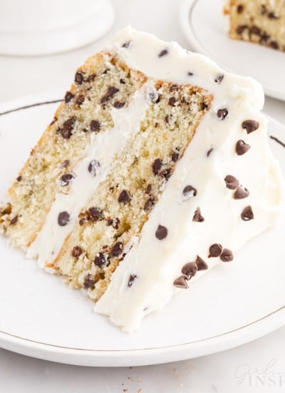 A small white dish with a slice of Chocolate Chip Cake on it.