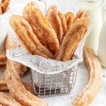 Churros in a basket lined with paper.