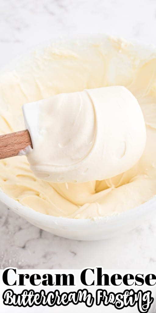 Plastic spatula held above a mixing bowl with cream cheese buttercream frosting.