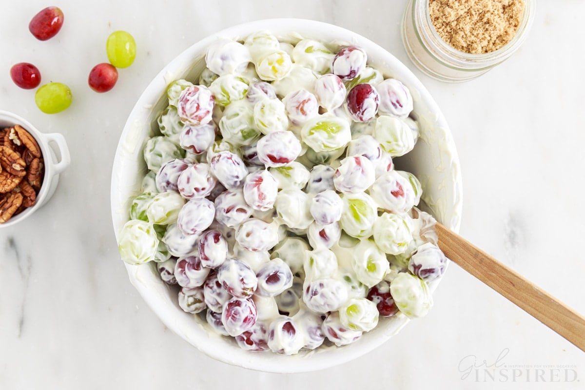 Grapes coated in creamy dressing in a salad bowl.