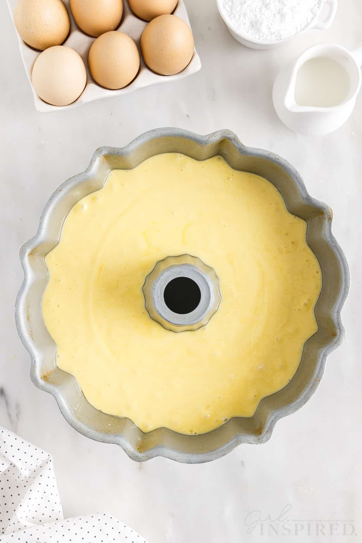 Duncan Hines Lemon Cake Mix Recipe batter in a bundt pan next to eggs.