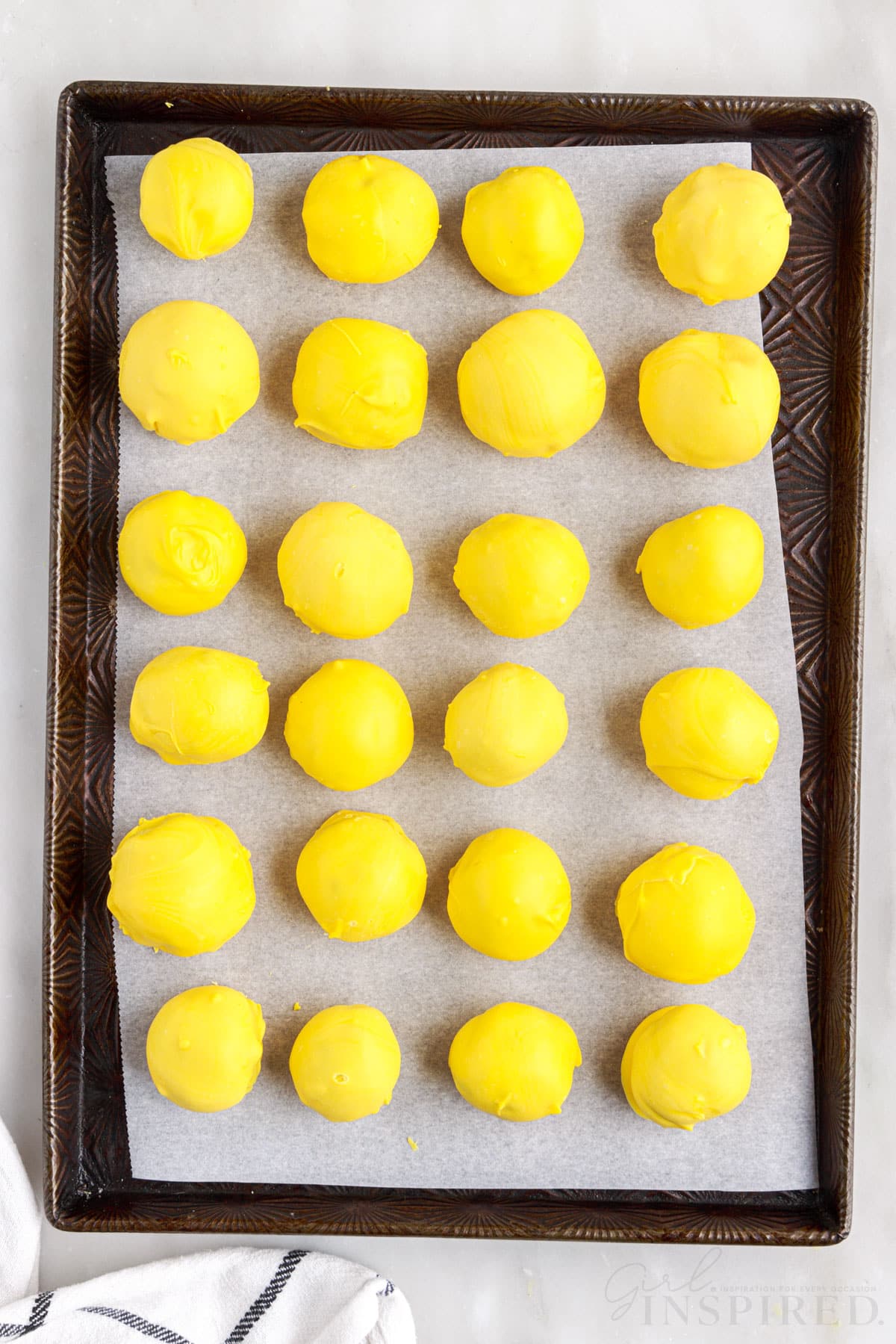 Yellow coated lemon blueberry bites on a sheet pan.