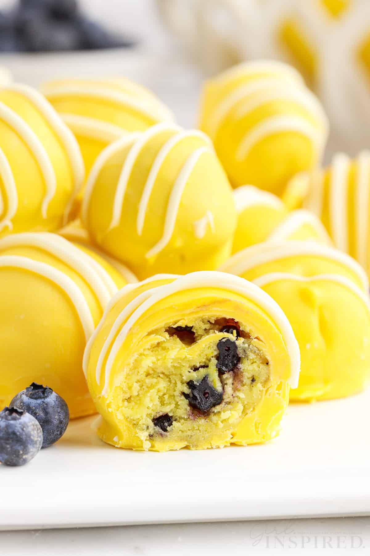 Side view of lemon blueberry bites on a platter with one sliced open.