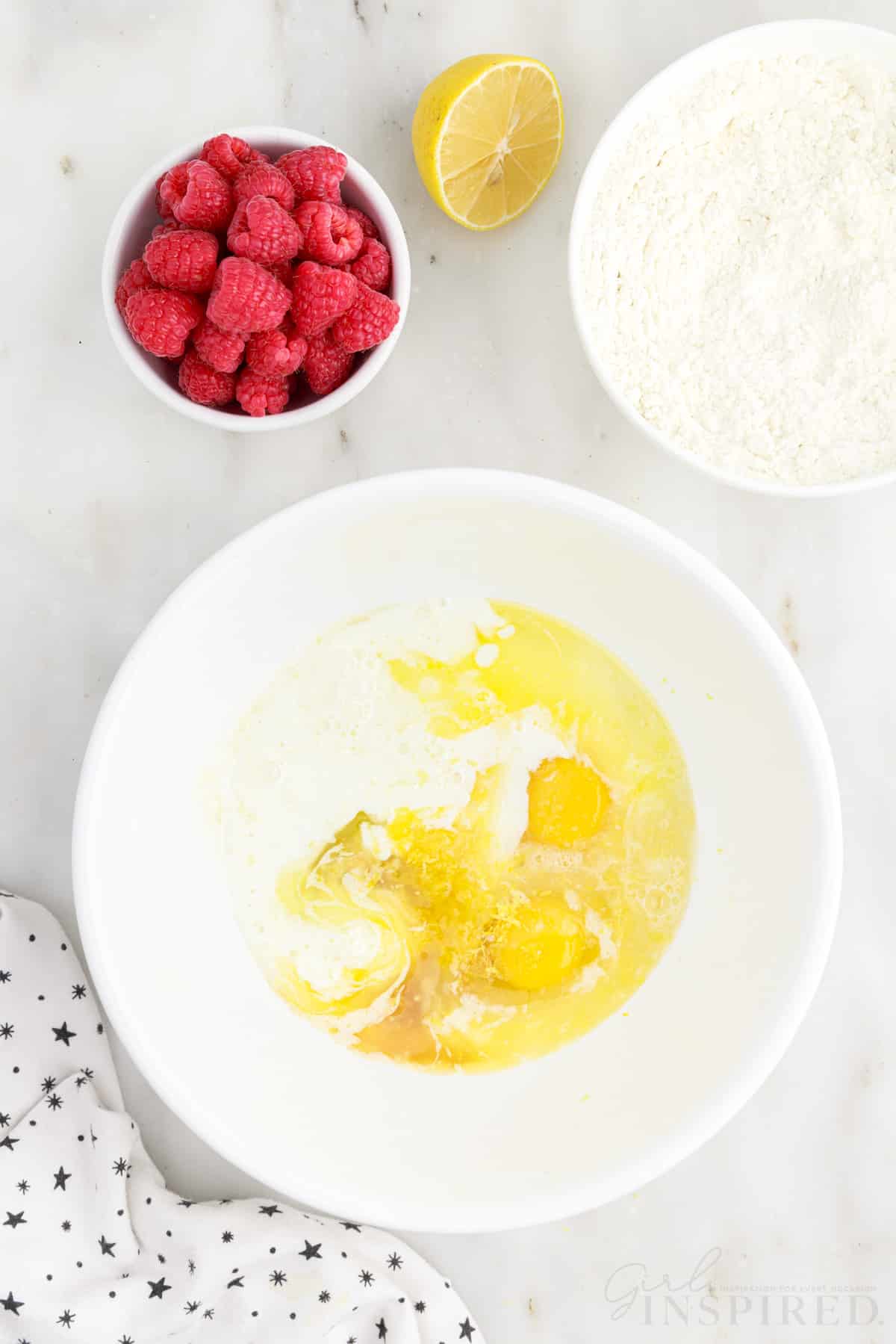 Eggs, melted butter, sugar, lemon extract, and vanilla in a mixing bowl.