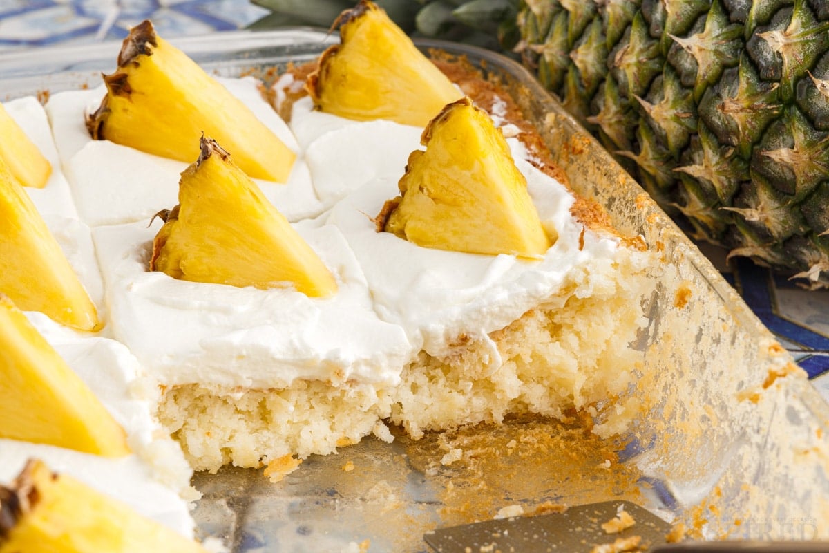 Side view of pan of pineapple angel food cake with slices removed.