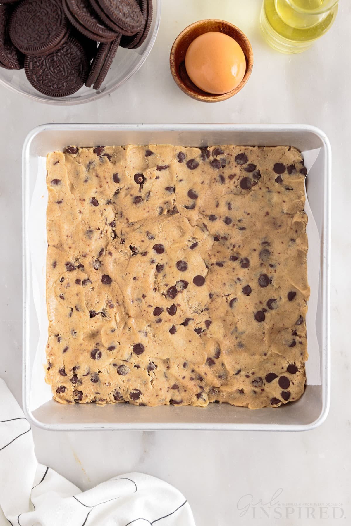 Cookie dough pressed into 8x8 parchment paper lined pan.