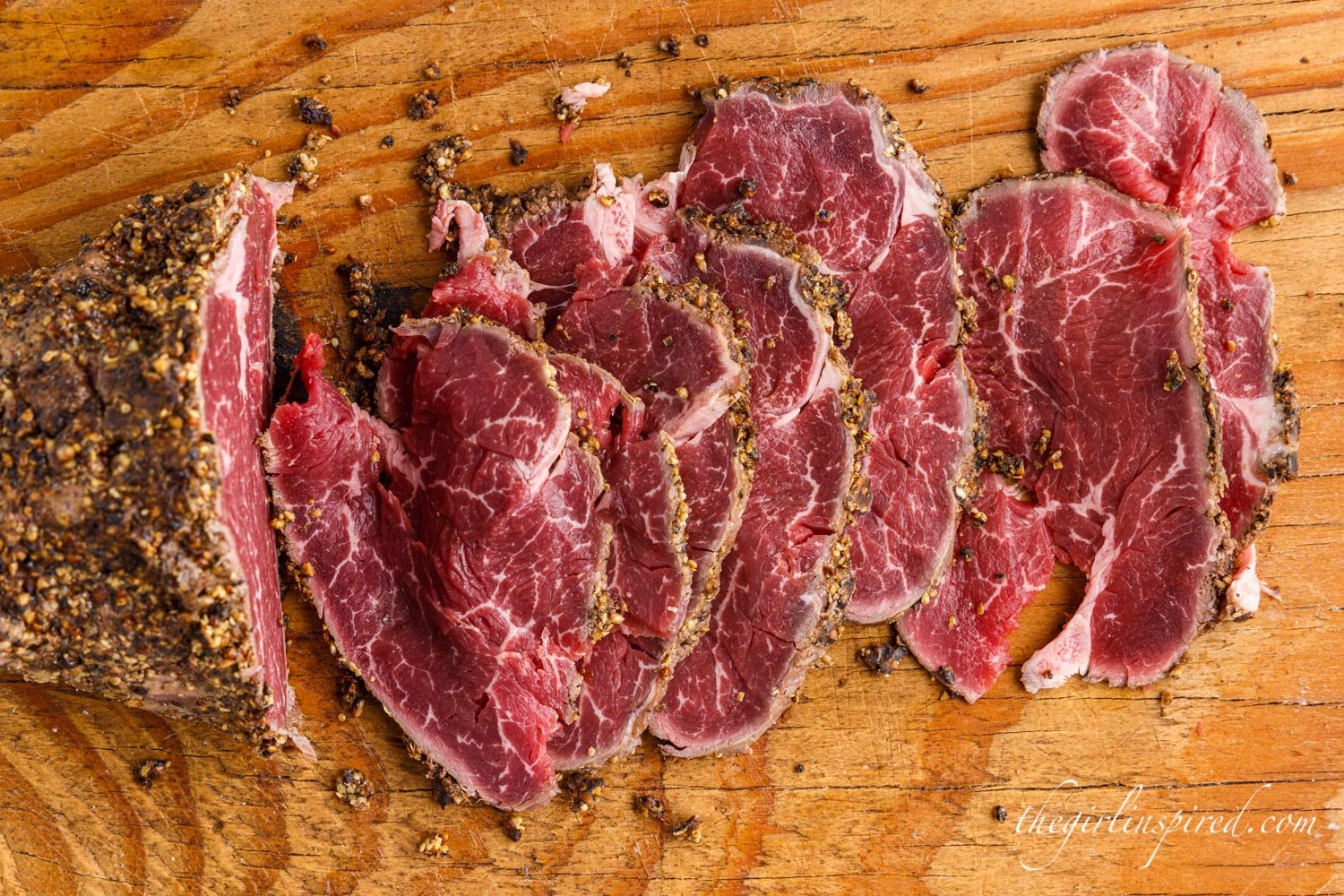 Overhead view of Beef Carpaccio sliced on cutting board.