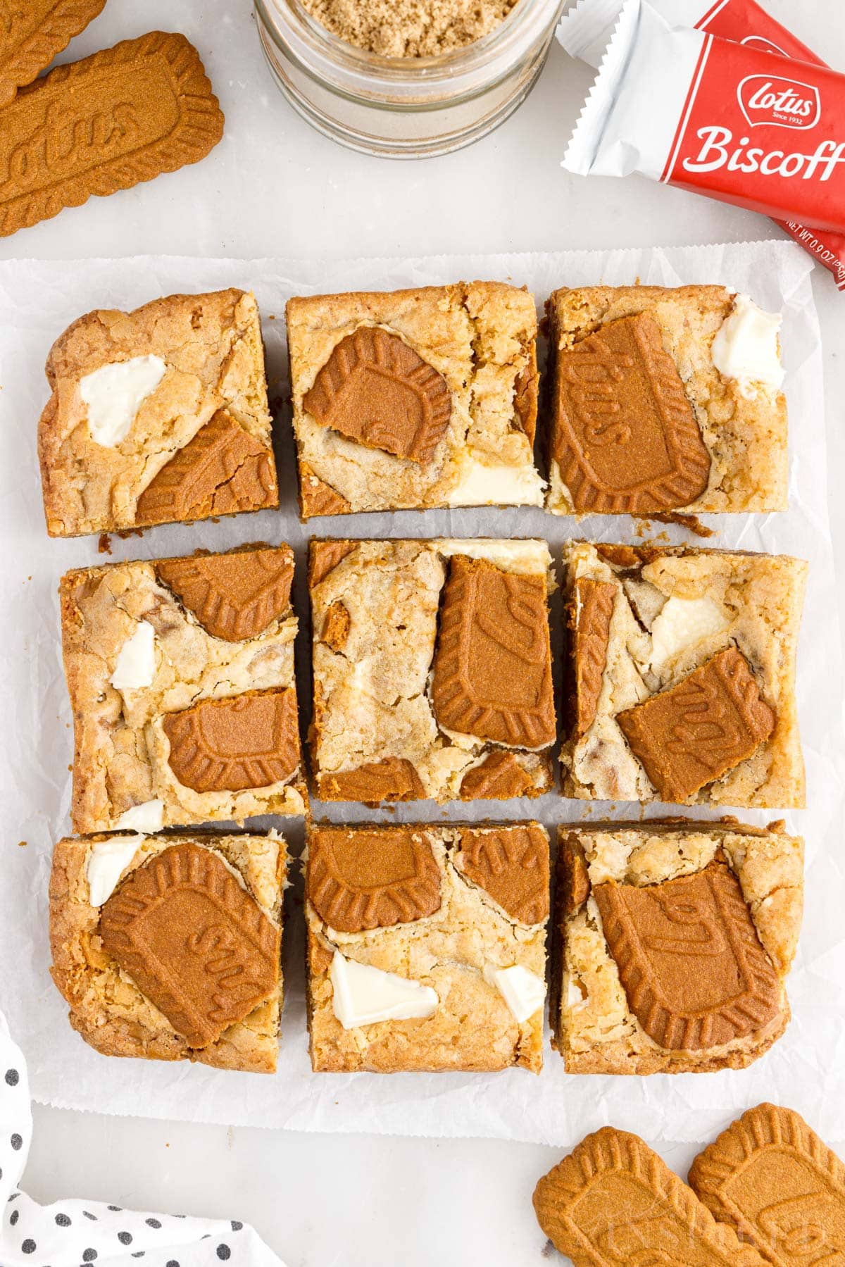Overhead view of Biscoff Blondies cut into 9 squares on parchment paper.