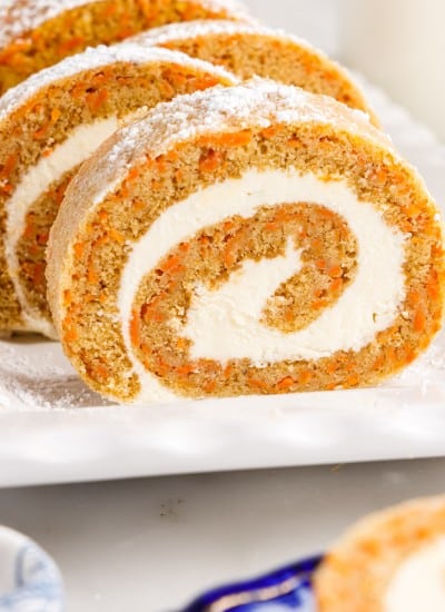 Carrot Cake Roll sliced into slices on a white platter.