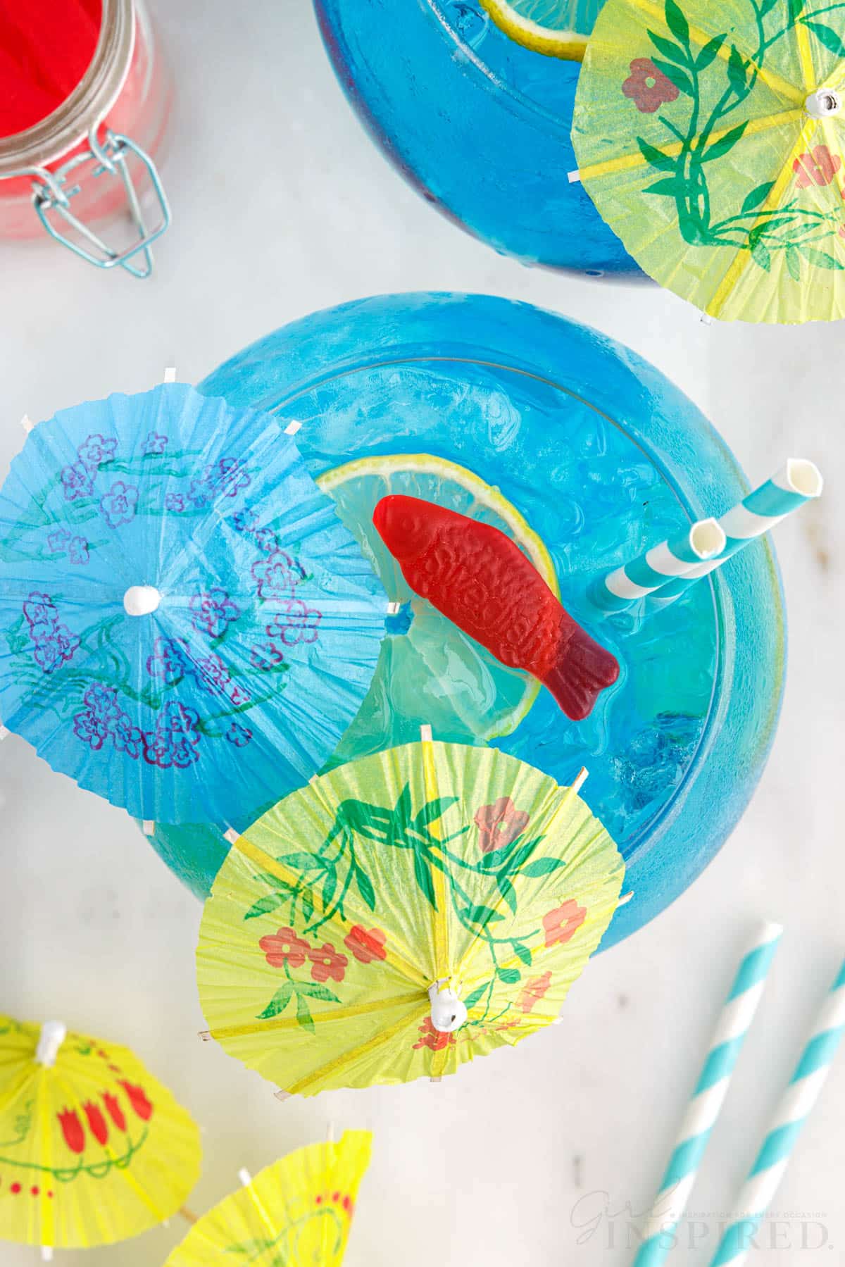 Overhead view of a Fish Bowl Drink with umbrellas and Swedish fish.
