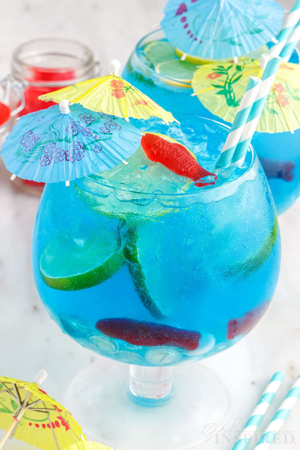 Fish Bowl drinks garnished with limes, Swedish fish, and drink umbrellas.