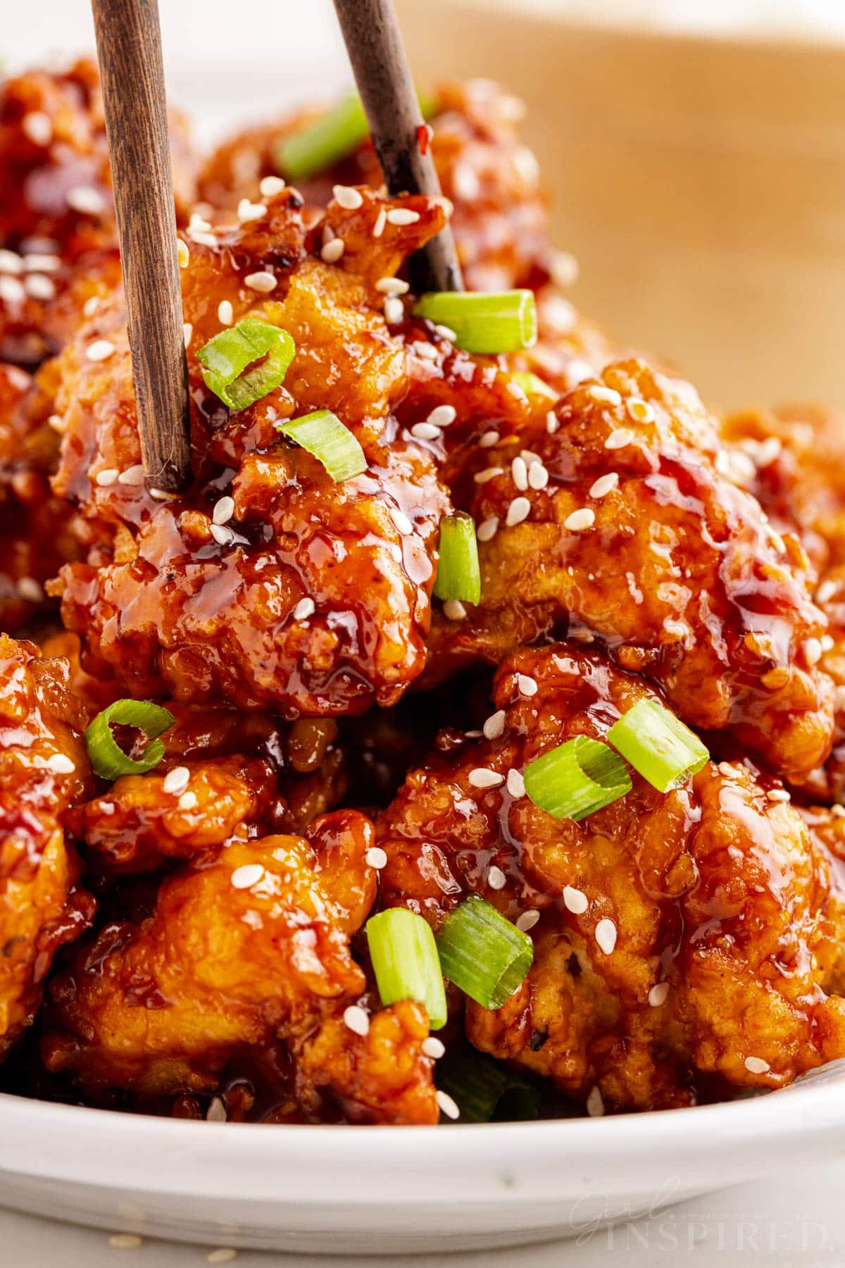 Close-up of General Tso Chicken with chopsticks.