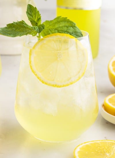 Close up of a glass of Limoncello Spritz with lemon slice and fresh mint.