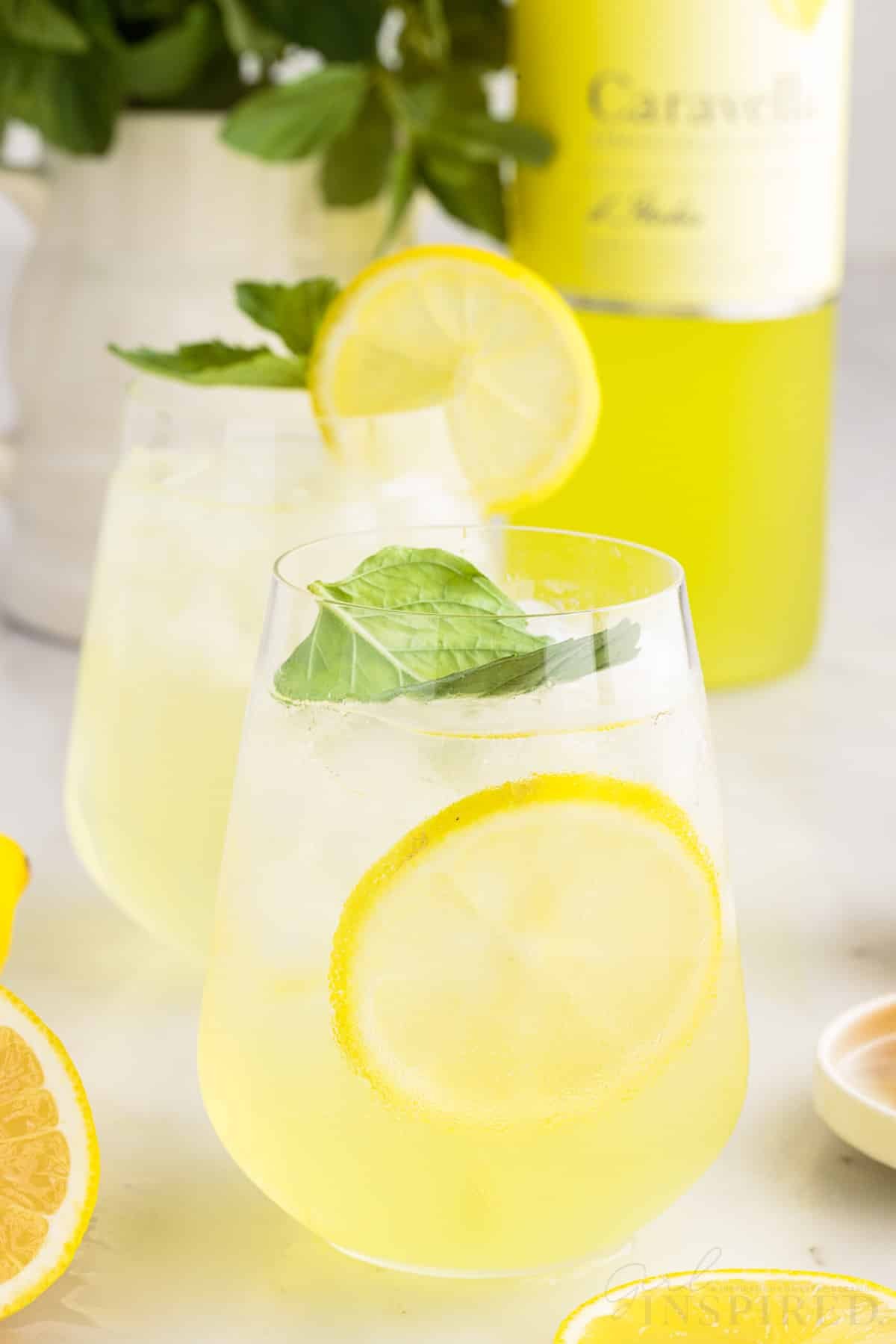 Glasses of Limoncello Spritz and a bottle of Limoncello in the background.