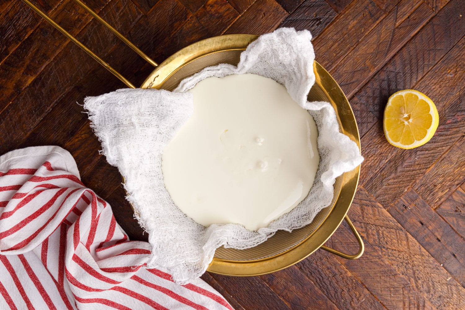 Mascarpone Cheese sitting in a cheese cloth and strainer.