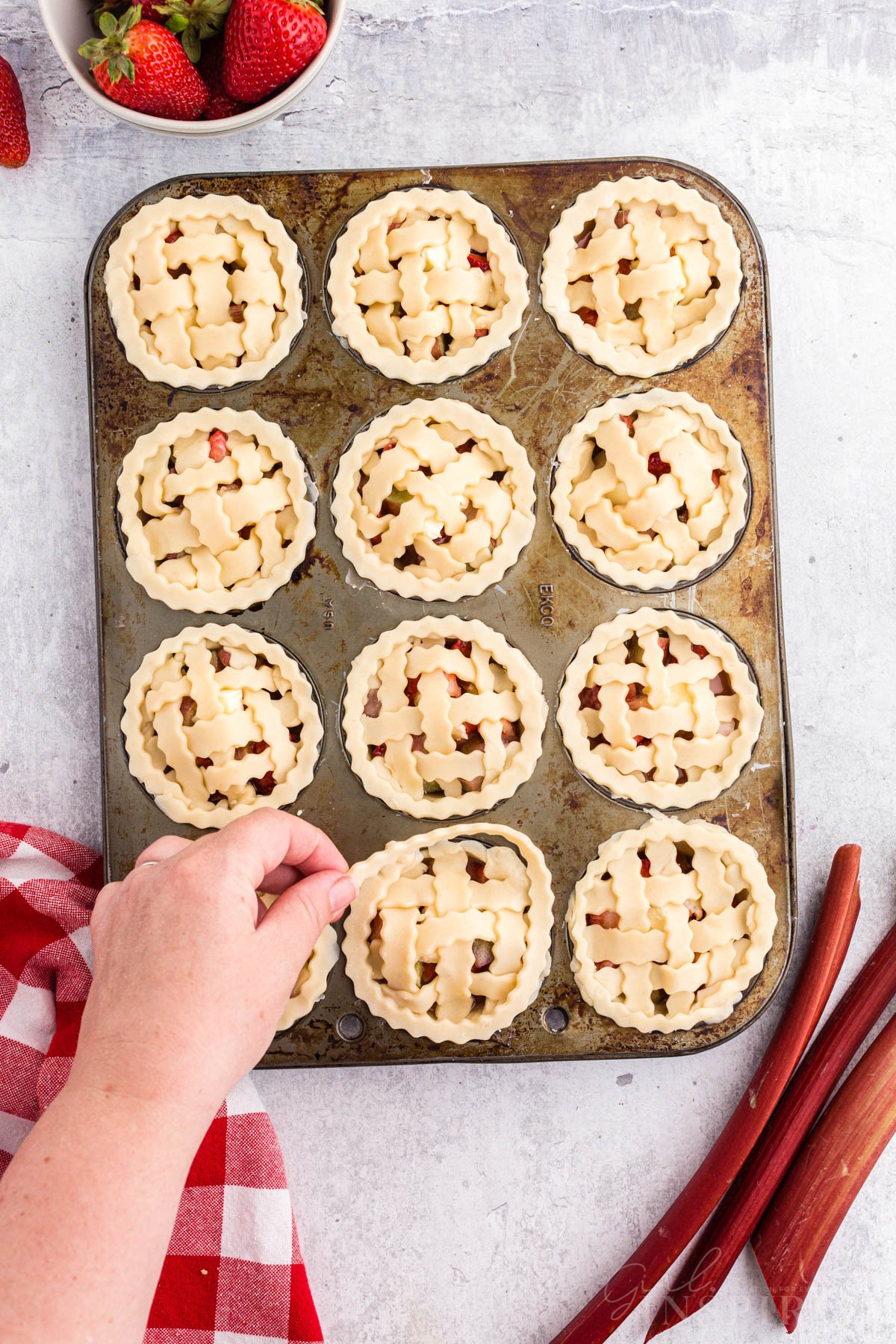 Lattice added to the edge of the Strawberry Rhubarb Mini Pies in muffin tins.