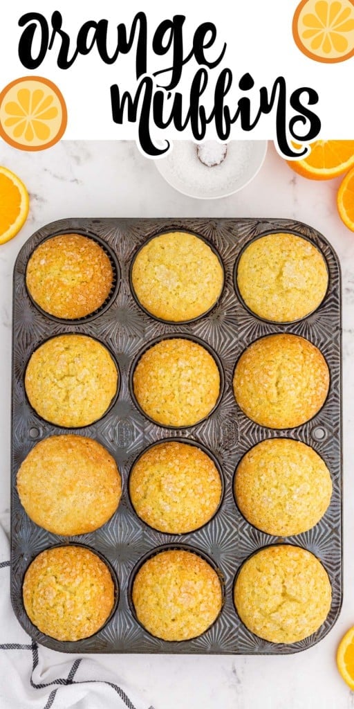 Overhead shot of Baked orange muffins in a metal muffin tin on a marble counter top.
