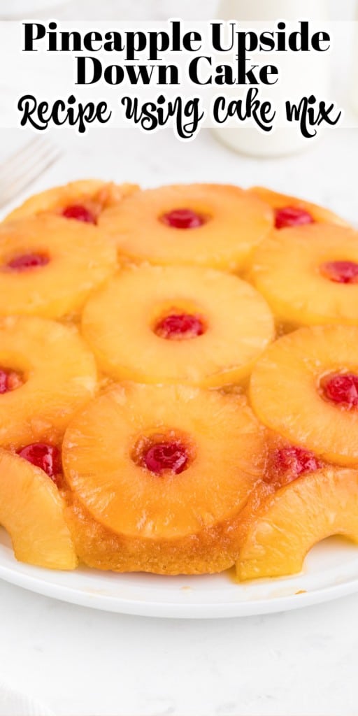Pineapple upside down cake on a white serving plate on a marble countertop.