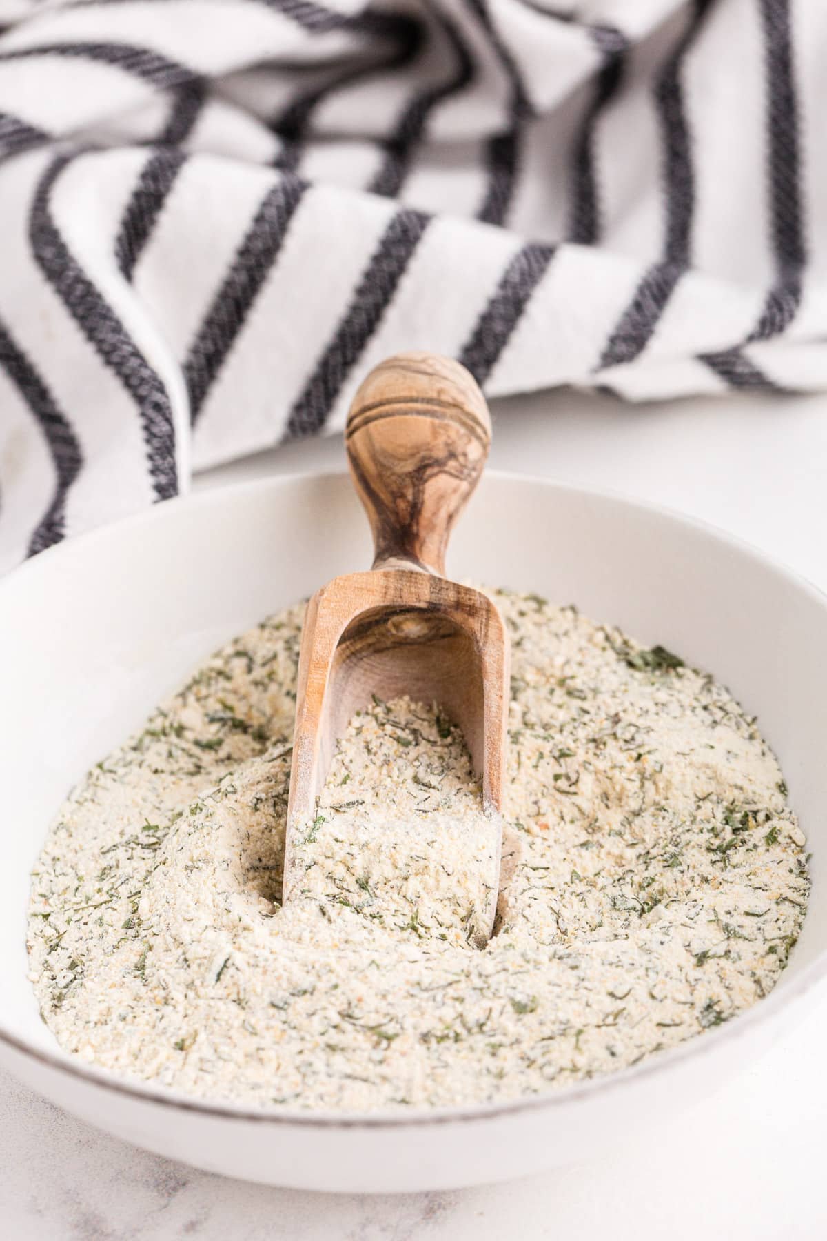 Bowl of simple ranch seasoning packet recipe on a white marble countertop.