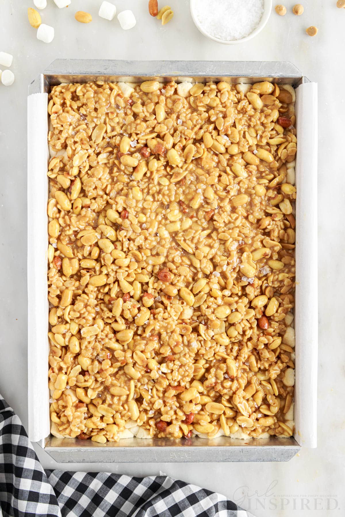 Salted Nut Roll Bars in a parchment paper lined 9x13.