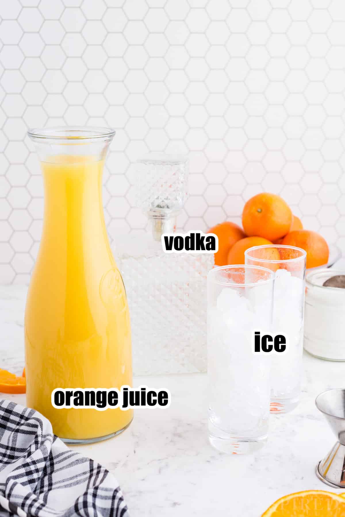 Screwdriver drink ingredients on a white marble countertop.