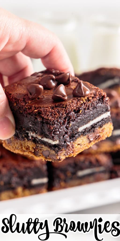 a slutty brownie held in hand with more brownies in the background
