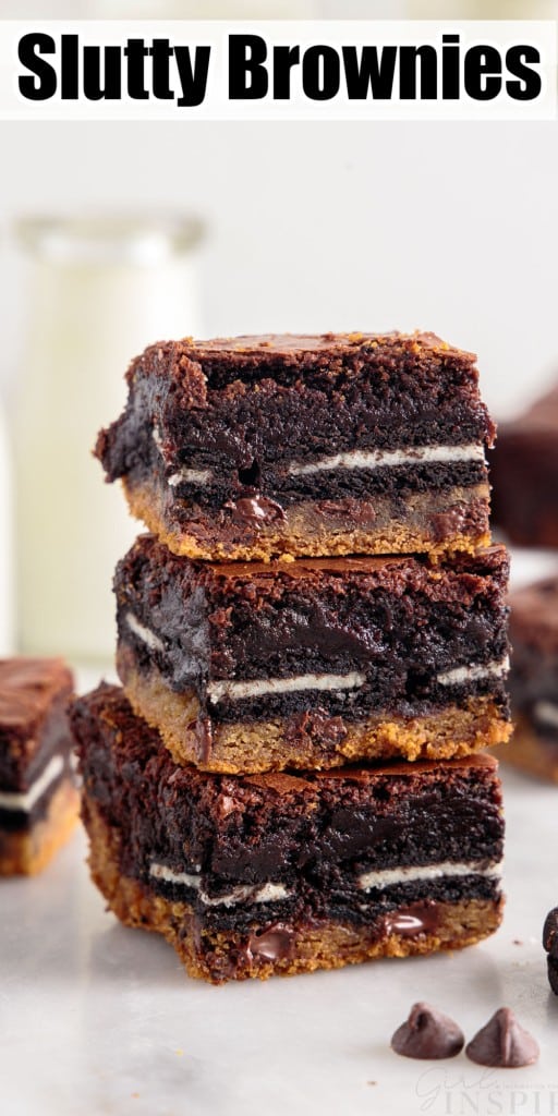 Three Slutty Brownies stacked on each other with brownies and milk in the background.