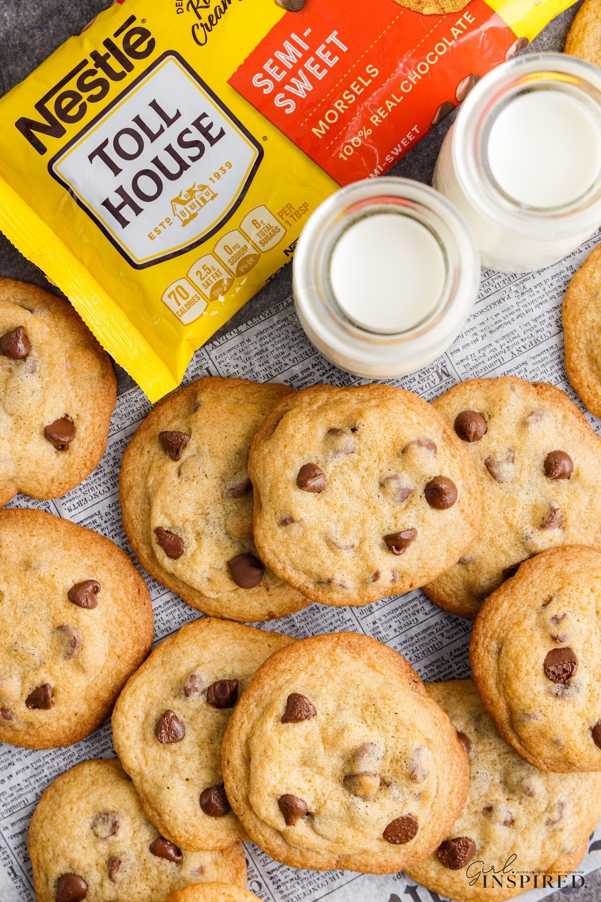 Spread of Toll house chocolate chip cookies with two glasses of milk and a bag of Nestle Toll house chocolate chips.