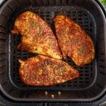 Three Air Fryer Boneless Chicken Breasts in an air fryer basket after being cooked.