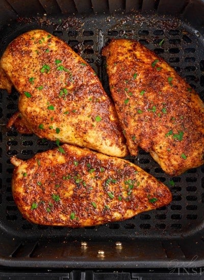 Three Air Fryer Boneless Chicken Breasts in an air fryer basket after being cooked.