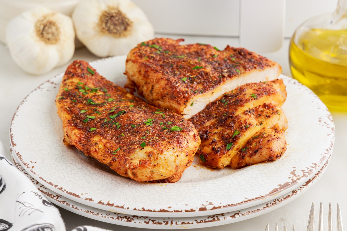 Air Fryer Boneless Chicken Breasts on a plate, half of one breast cut into slices.