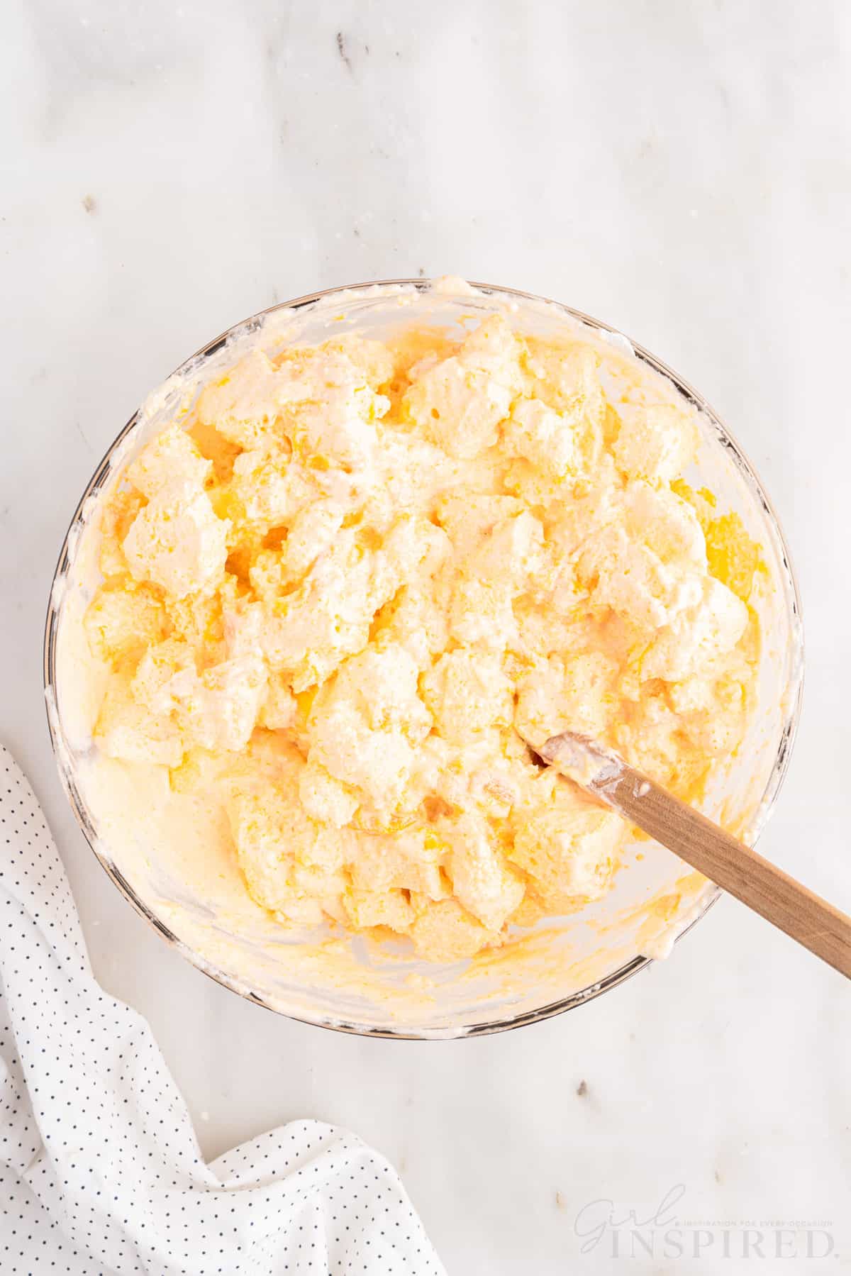 Apricot Delight mixture stirred together in a mixing bowl with a spatula.