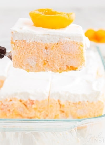 A slice of Apricot Delight on a spatula above the 9x13 pan.