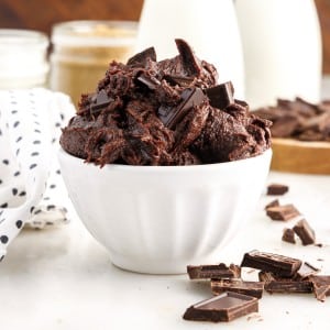 Front view of Edible Brownie Batter in a white serving dish chocolate chunks on the counter.