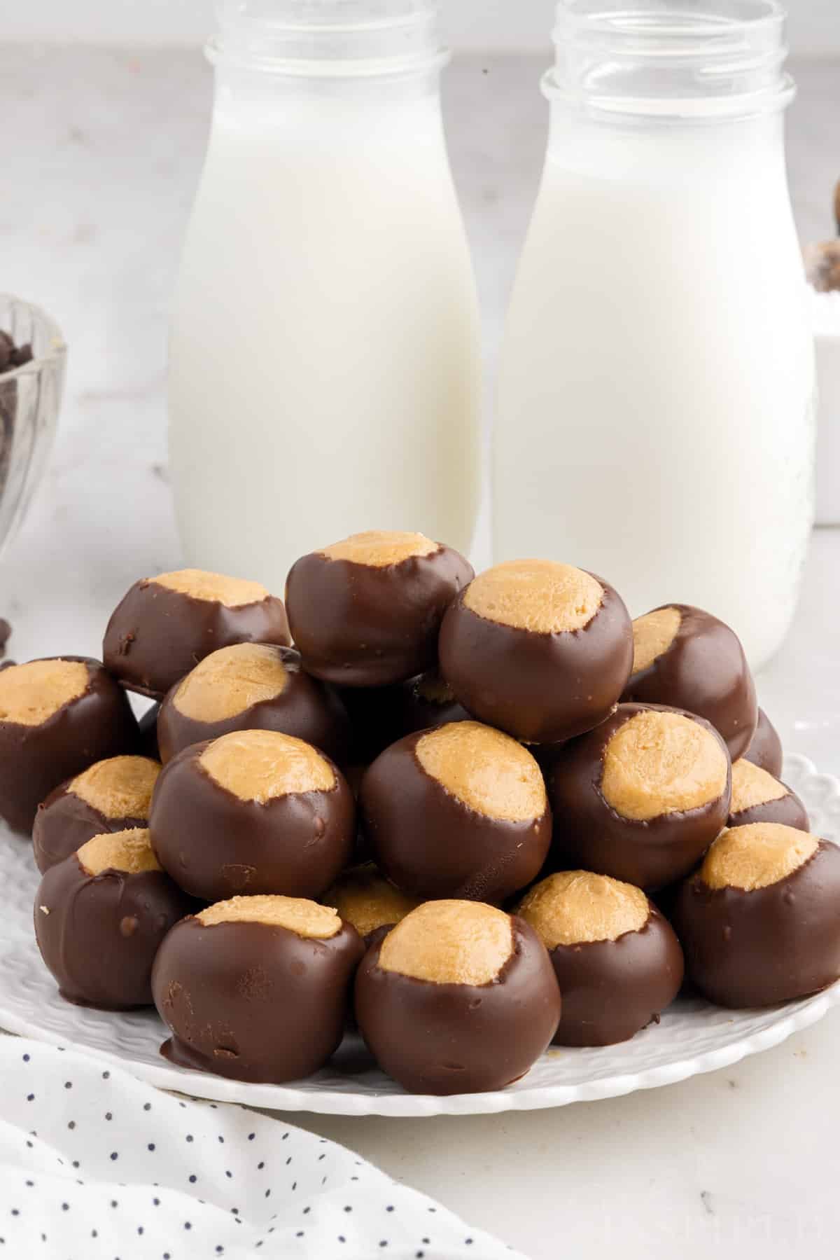 A plate of Buckeye Balls with milk in the background.