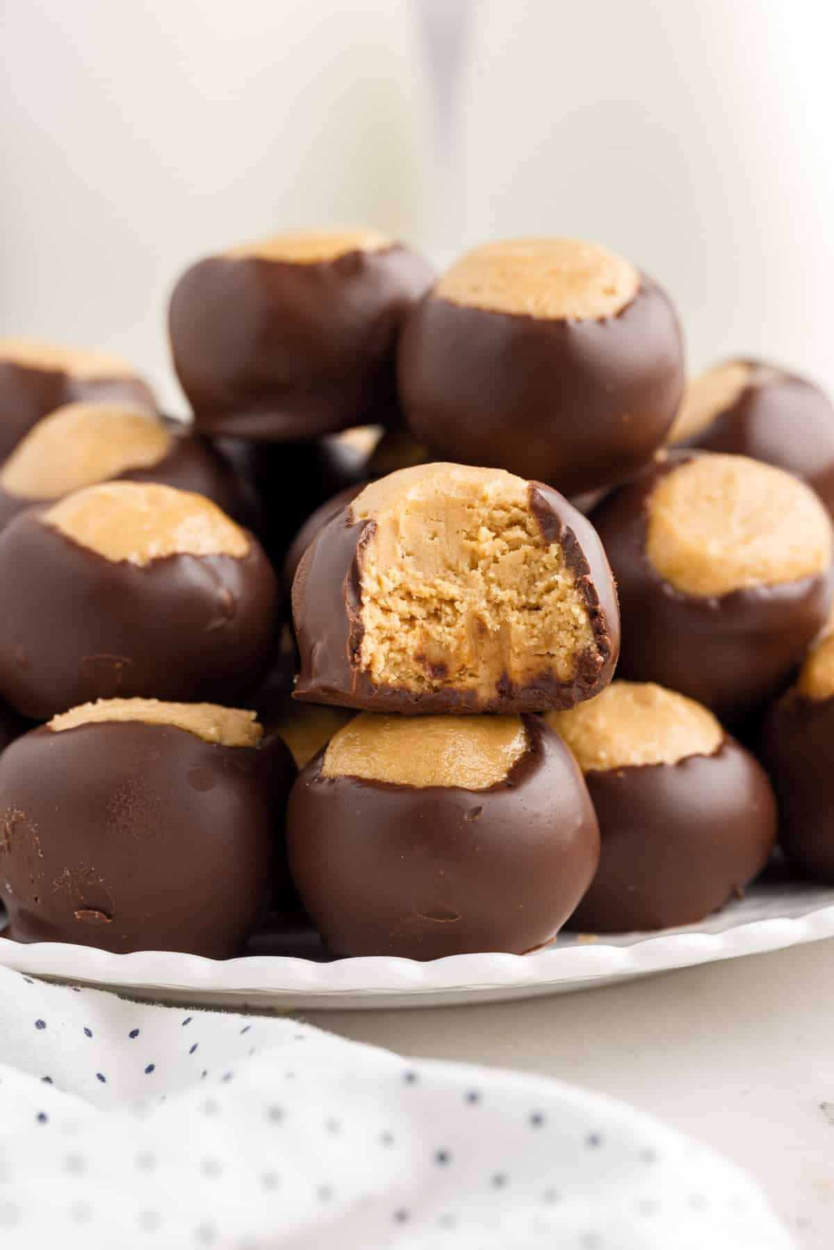 Buckeye Balls stacked on a plate with a bite taken from one.