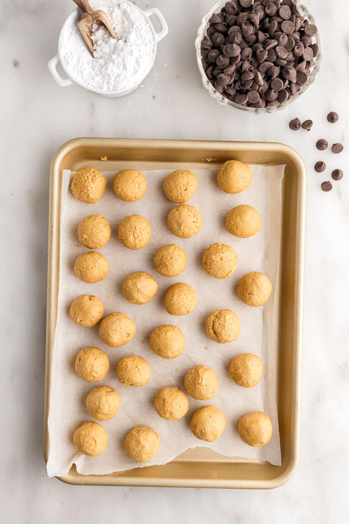 Buckeye Balls on a parchment paper lined cookie sheet.