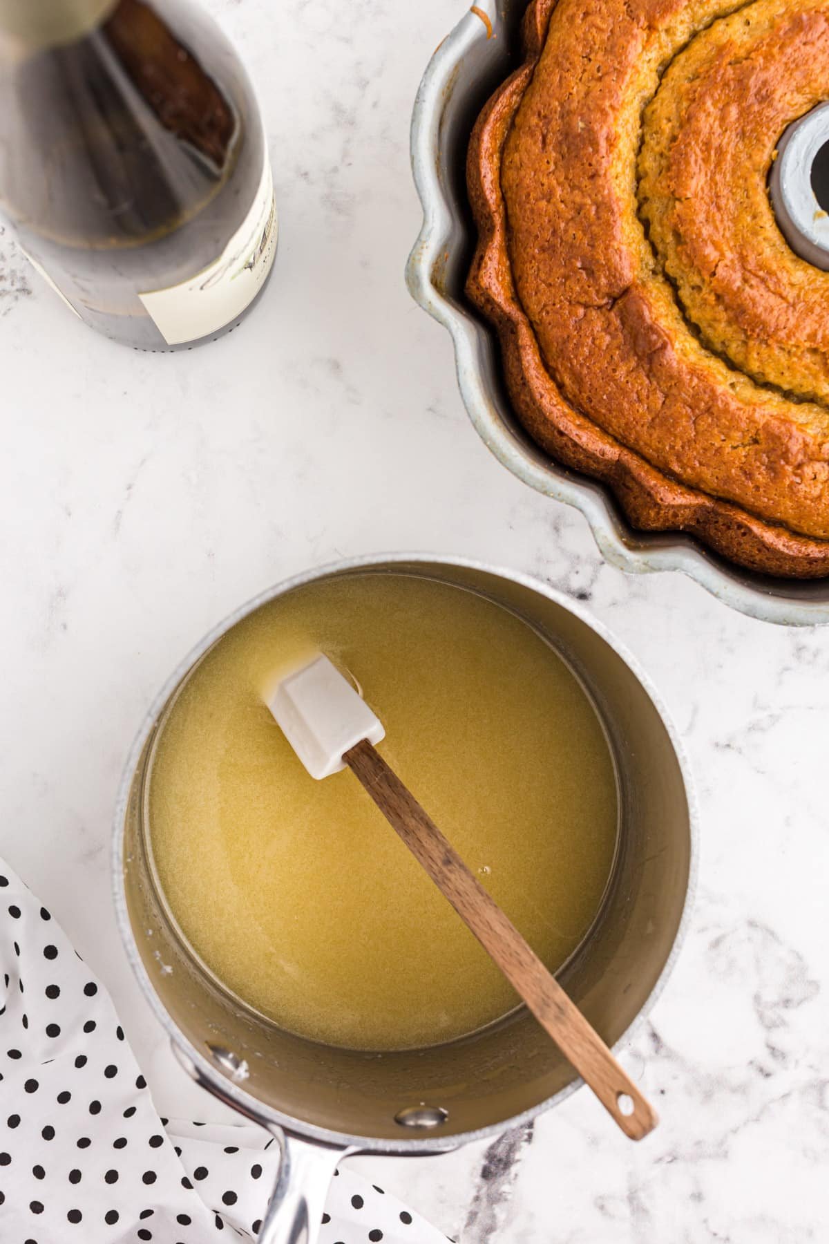 Crack cake glaze in a saucepan with a plastic spatula.