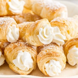 Cream Horns stacked on each other on a plate.